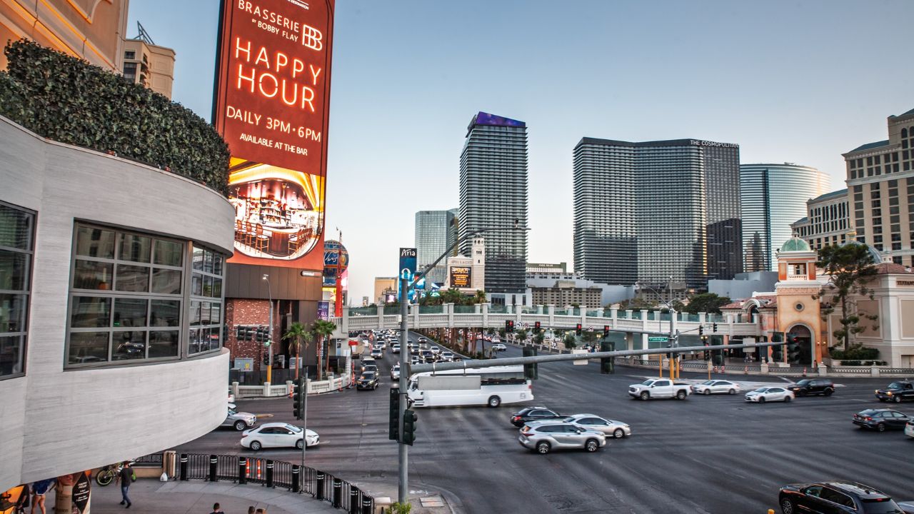 LAS VEGAS, AUGUST 21, 2024: Elevated twilight view from Horseshoe footbridge shows heavy traffic on Las Vegas Boulevard, by towering resorts, billboards and pedestrians, showing driving in vegas.