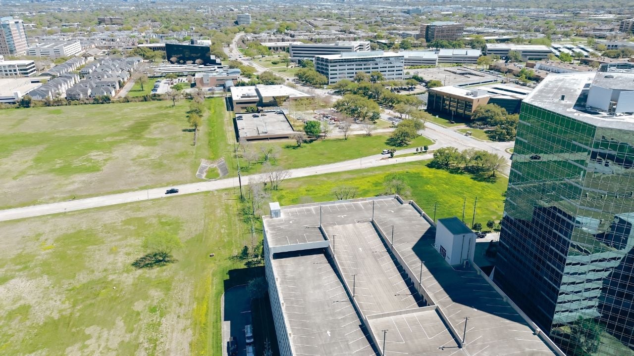 Westchase business district and residential neighborhood along Richmond Avenue and modern multistorey car park parking multilevel garage structure in Houston, Texas, glass office building, aerial. USA