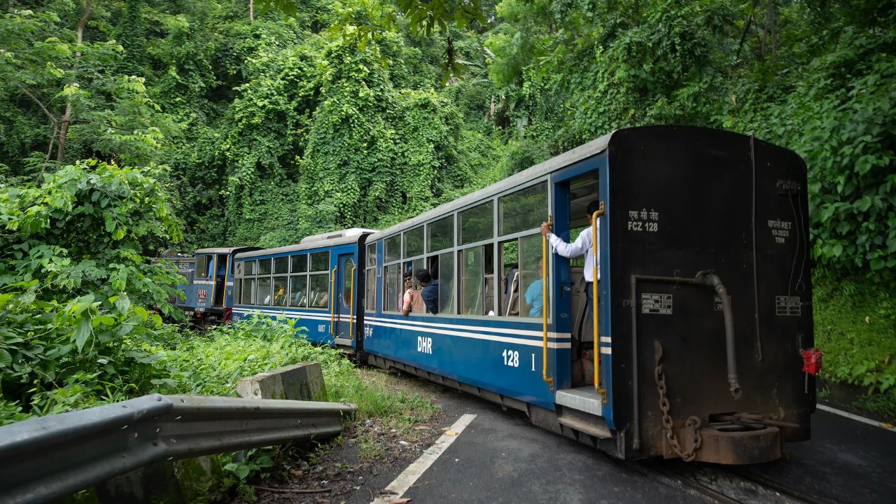 Darjeeling,West Bengal,India - 10th August 2023 : Diesel Toy train passing through Himalayan roads and jungle. Darjeeling Himalayan Railway, narrow gauge railway between New Jalpaiguri and Darjeeling.