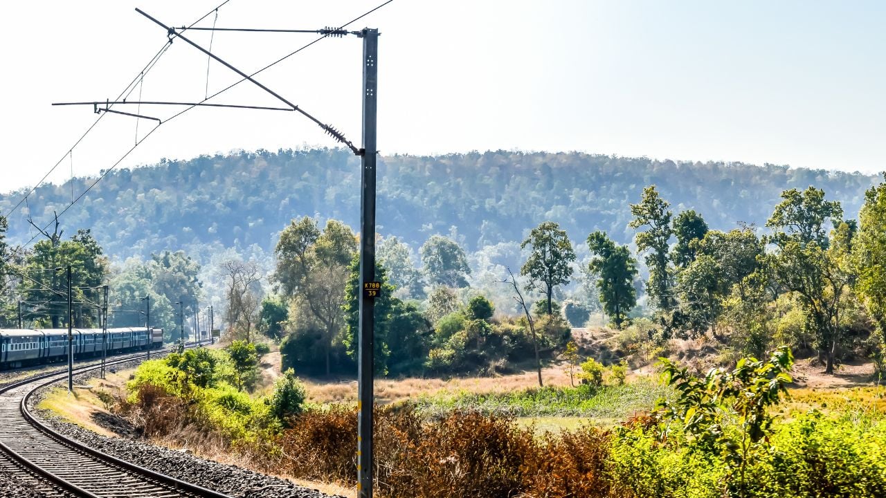 Scenic Train running in sharp bends through dense forest. Konkan Railway Journey, Western Ghats, India.