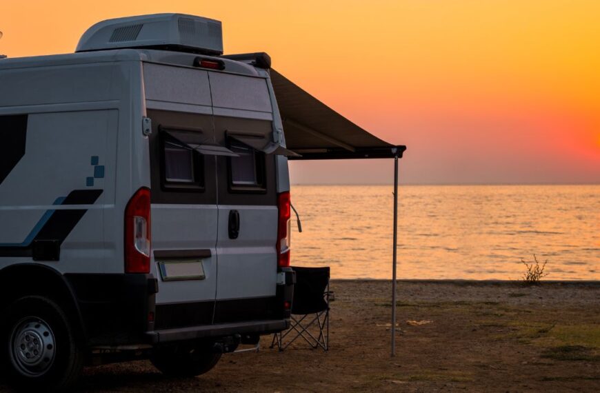 Campervan is parked on the beach at sunset. Campervan is parked on the beach next to the sea - wild camping in Croatia, Montenegro, Albania or Greece. Summer road trip