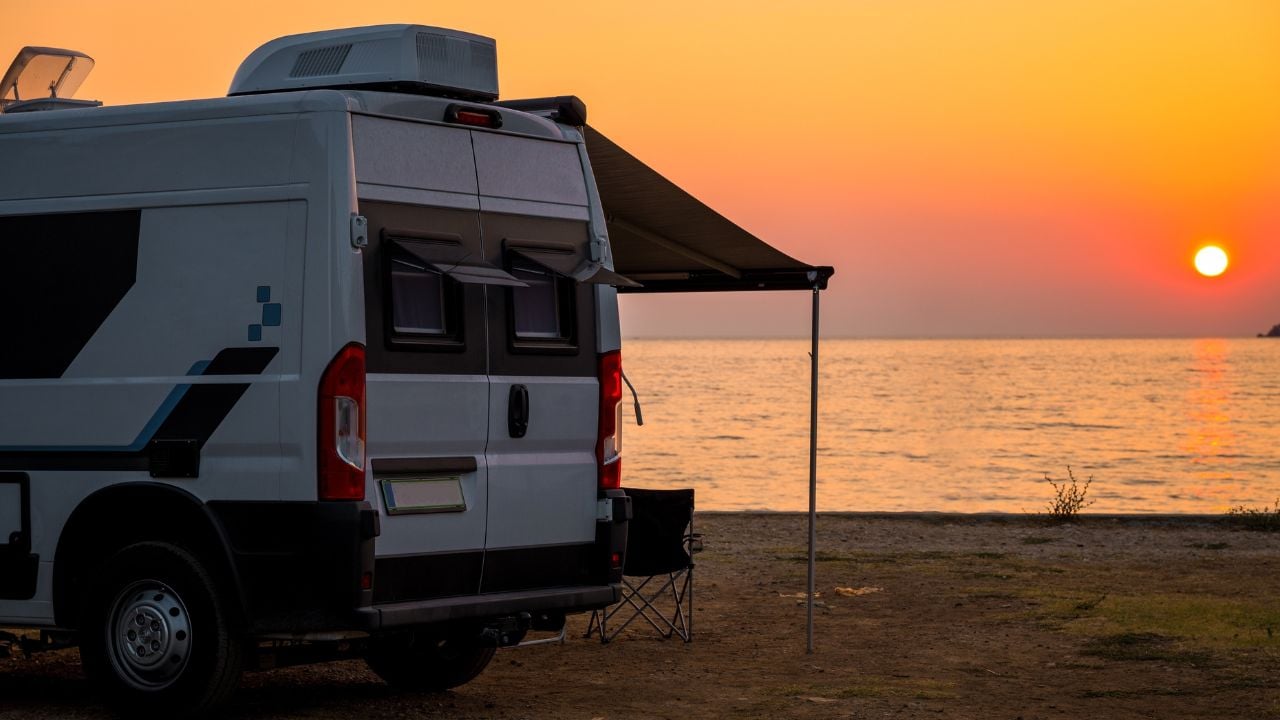 Campervan is parked on the beach at sunset. Campervan is parked on the beach next to the sea - wild camping in Croatia, Montenegro, Albania or Greece. Summer road trip
