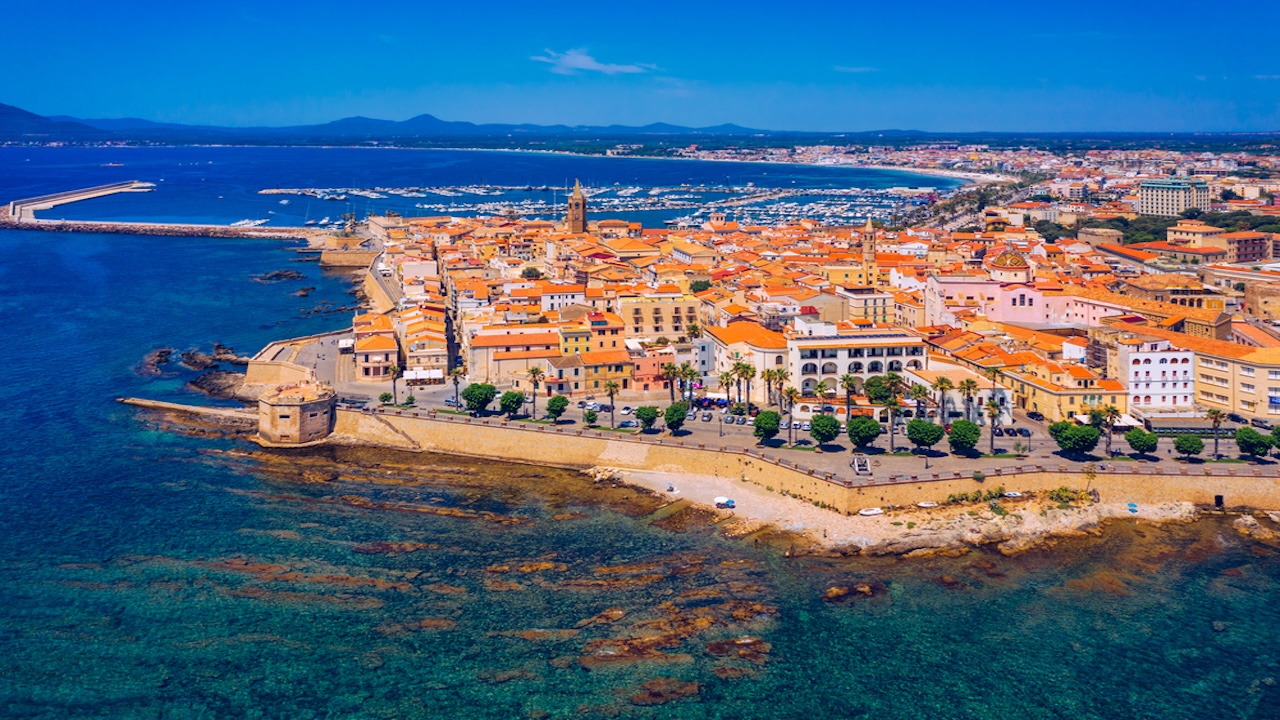 Aerial view over Alghero old town, cityscape Alghero view on a beautiful day with harbor and open sea in view. Alghero, Italy. Panoramic aerial view of Alghero, Sardinia, Italy.