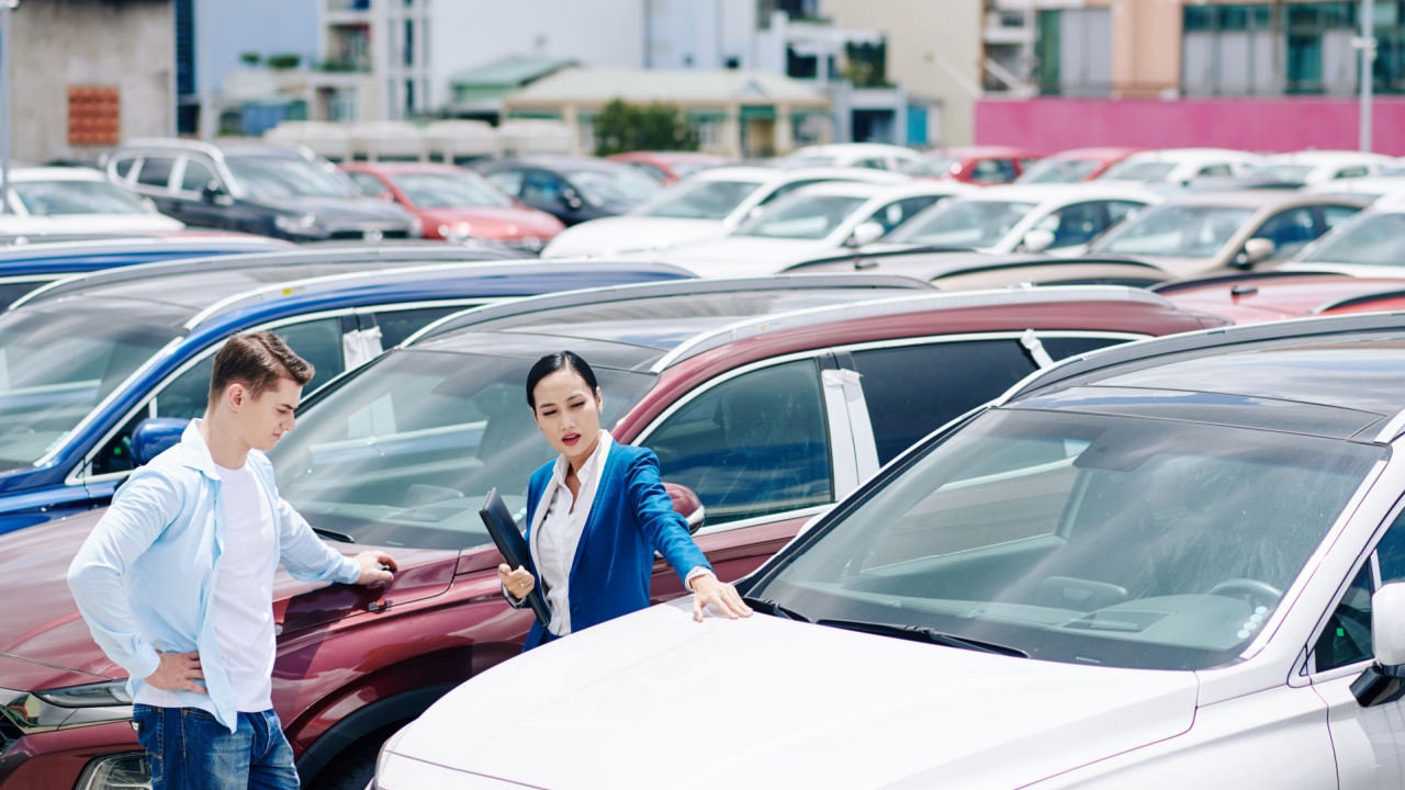 Female dealership manager helping customer to choose a new car