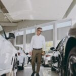 Full body adult man customer male buyer client choose auto want to buy new automobile in modern car showroom . Sales concept