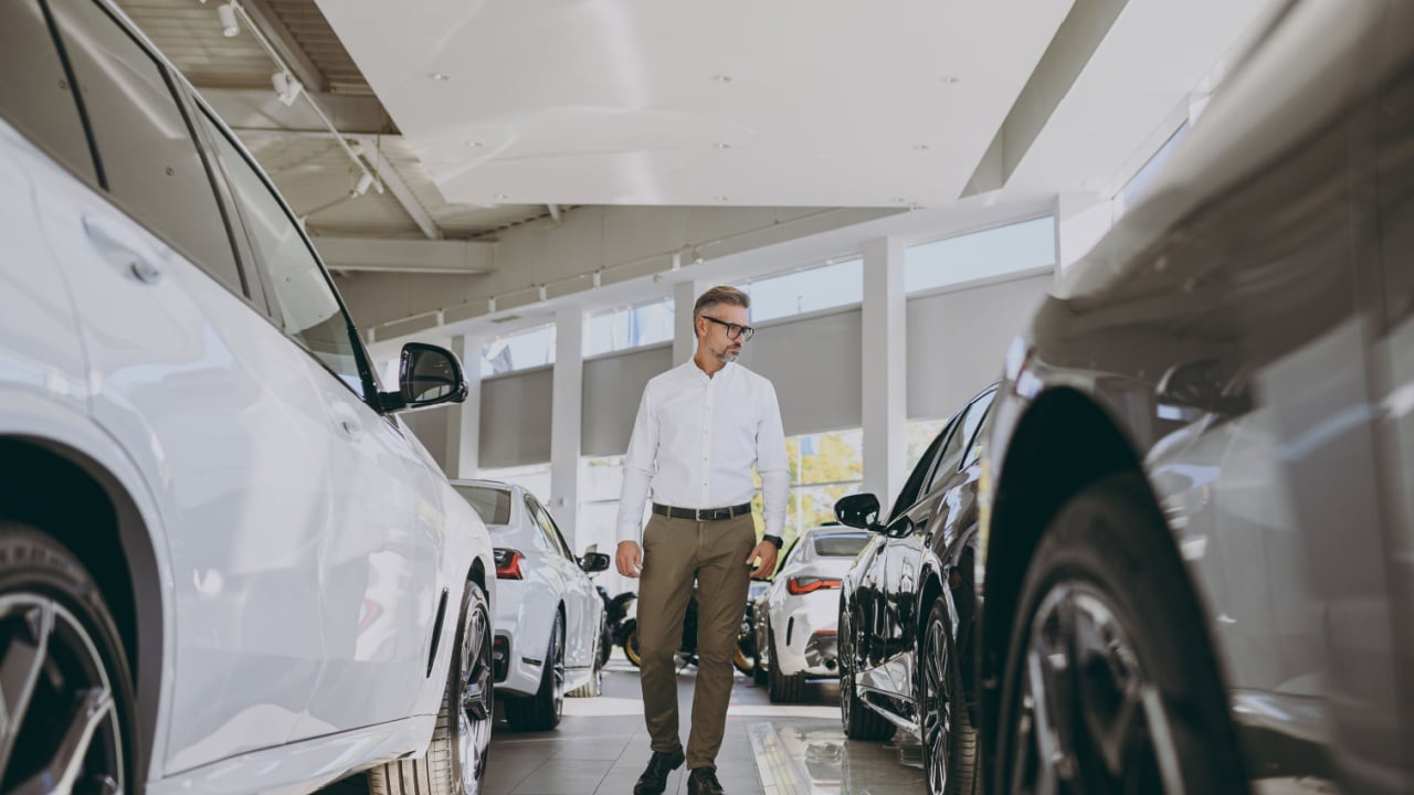 Full body adult man customer male buyer client choose auto want to buy new automobile in modern car showroom . Sales concept