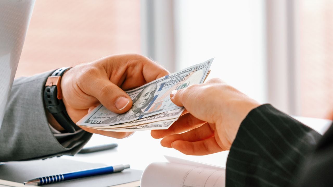 Businessman hand sending money to another business person. Transaction, payment, salary and banking concept. uds