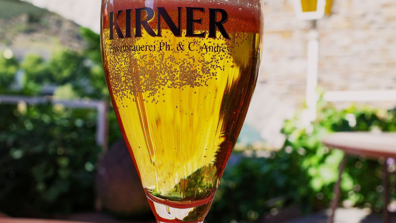 Cochem, Germany - August 15 2022: Cold glass of one of Germany's best beers from a private brewery. Kirner Beer by ph. c. andres brewery for over 200 years on the Mosel River.
