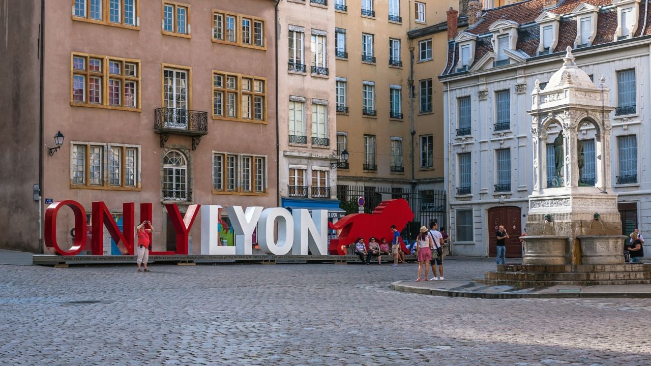 LYON, FRANCE - JULY 27: The famous big letters "ONLY LYON" on the Place Saint-Jean in the historical center of Lyon and people walking on the square, France on July 27, 2013. The attractions of Lyon