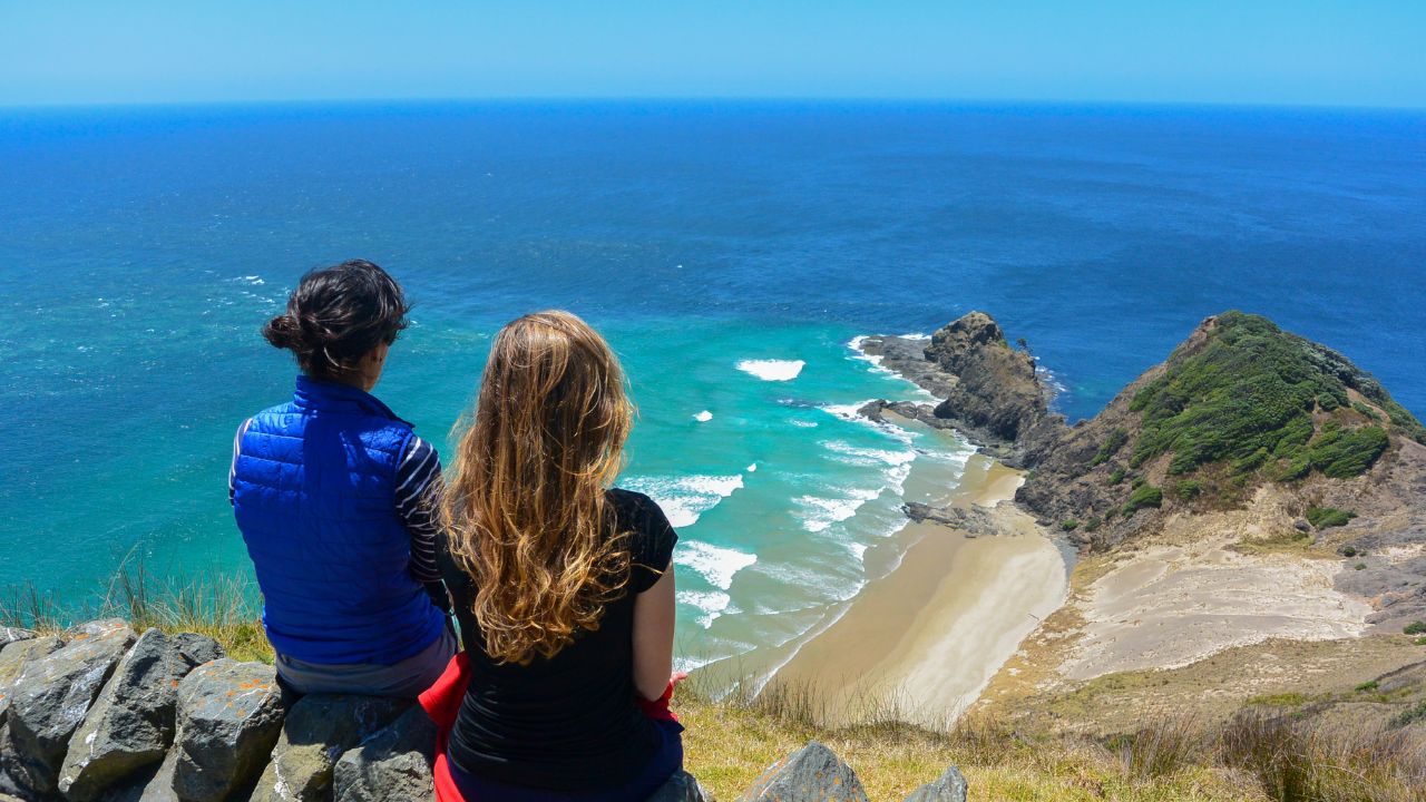 Two women looking at the view from Cape Reinga, north edge of New Zealand.