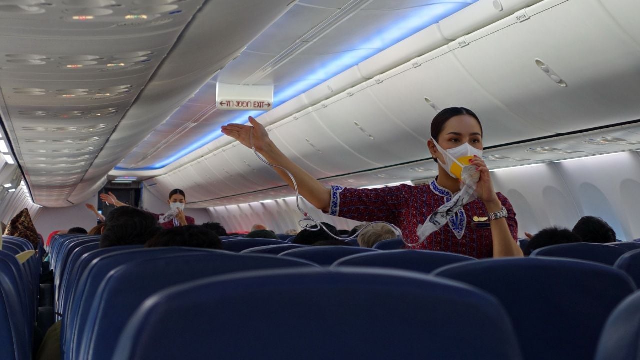 A Lion Air flight attendant wearing a mask gives a pre-flight safety demonstration on February 3, 2020 in Bangkok, Thailand. Airline staff routinely wear face masks due to the covid-19 pandemic.