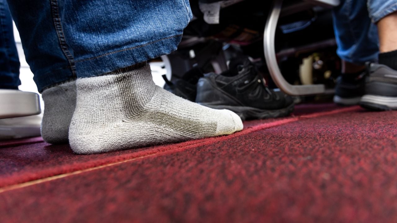 Relaxed aIrplane passenger seated in cabin with shoes removed