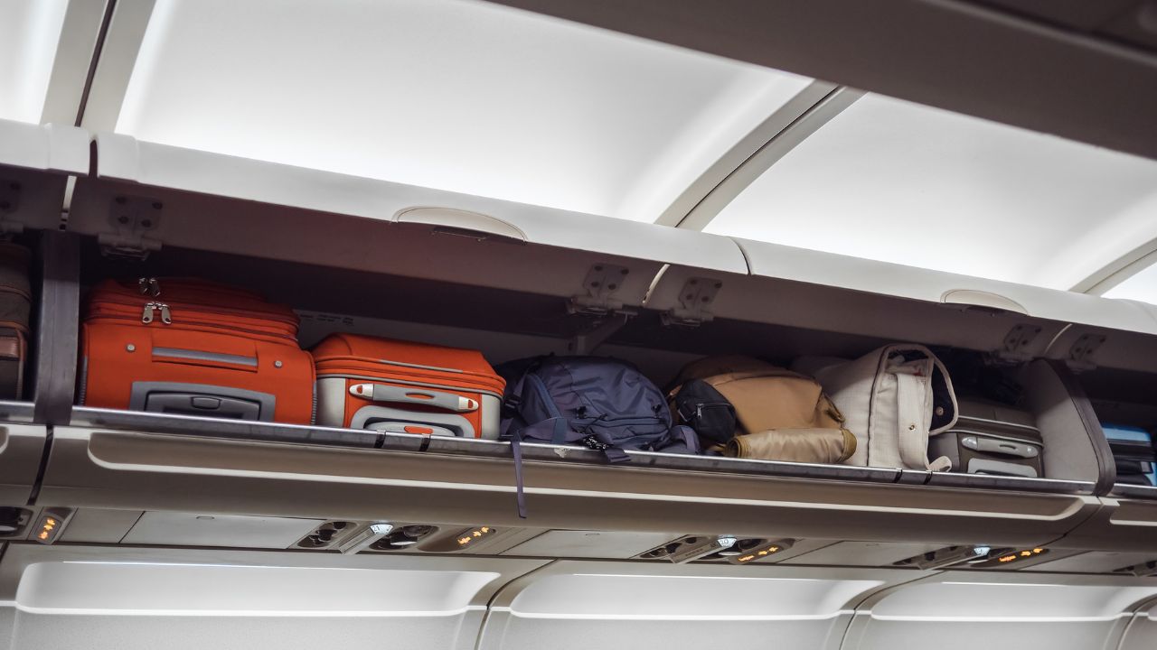 Luggage shelf with luggage in an airplane. Aircraft interior. Travel concept.