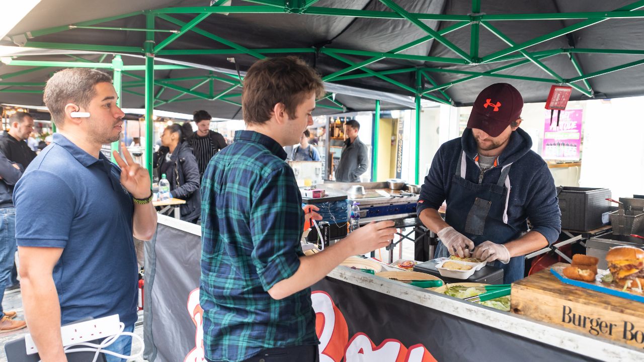 London, UK - September 12, 2018: Famous Brewer Market Street with Soho food stall and vendor outside and people ordering fresh burgers with sign