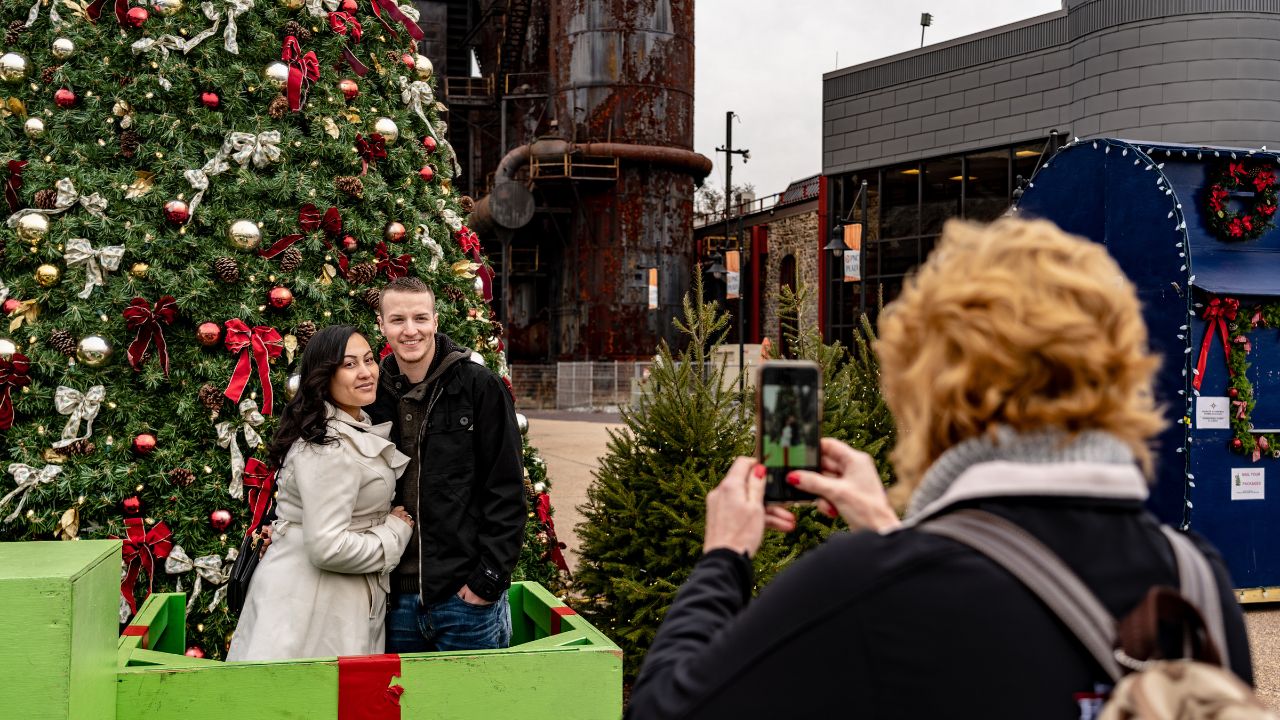 Bethlehem, PA, USA - December 9, 2018: Visitors pose for a photo at the Christkindlmarket. The Christmas market is held at Steel Stacks, a campus that hosts festivals, concerts & events.