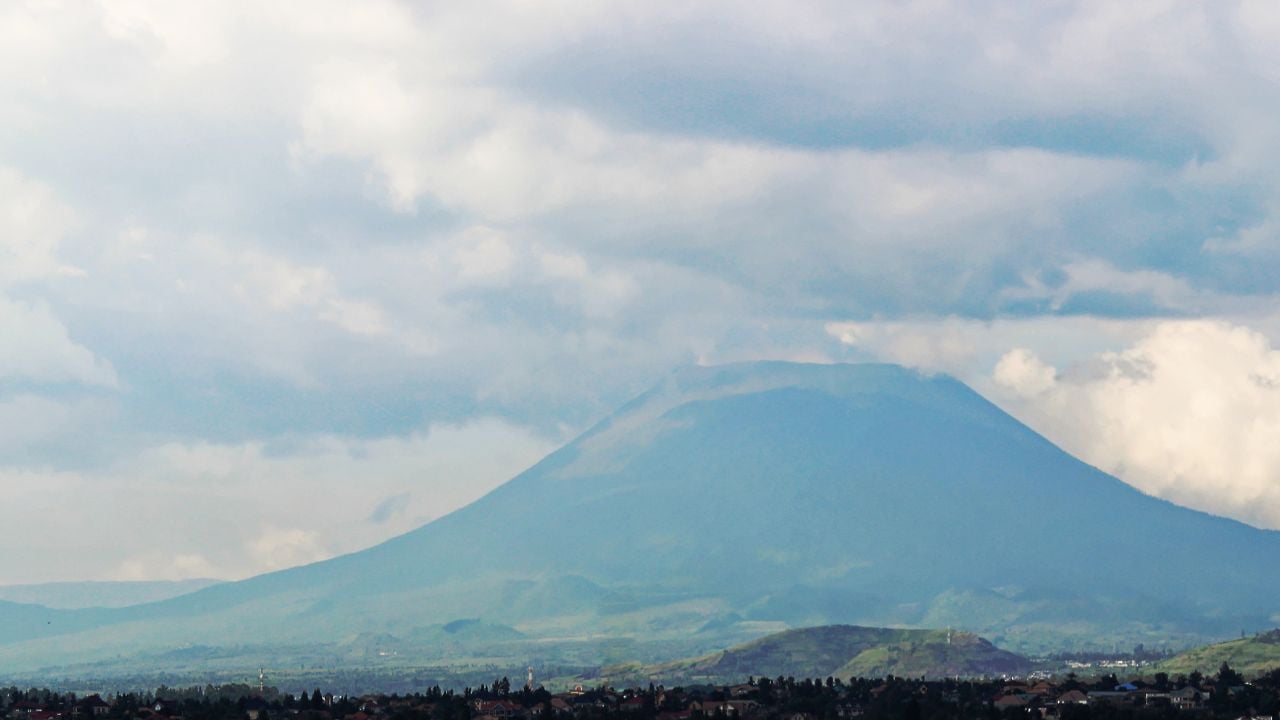 Nyiragongo Mountain in Virunga National Park, Democratic Republic of Congo (DRC).Active African volcano with lava lake. Panoramic view - misty, foggy landscape with clouds and mountain peak.