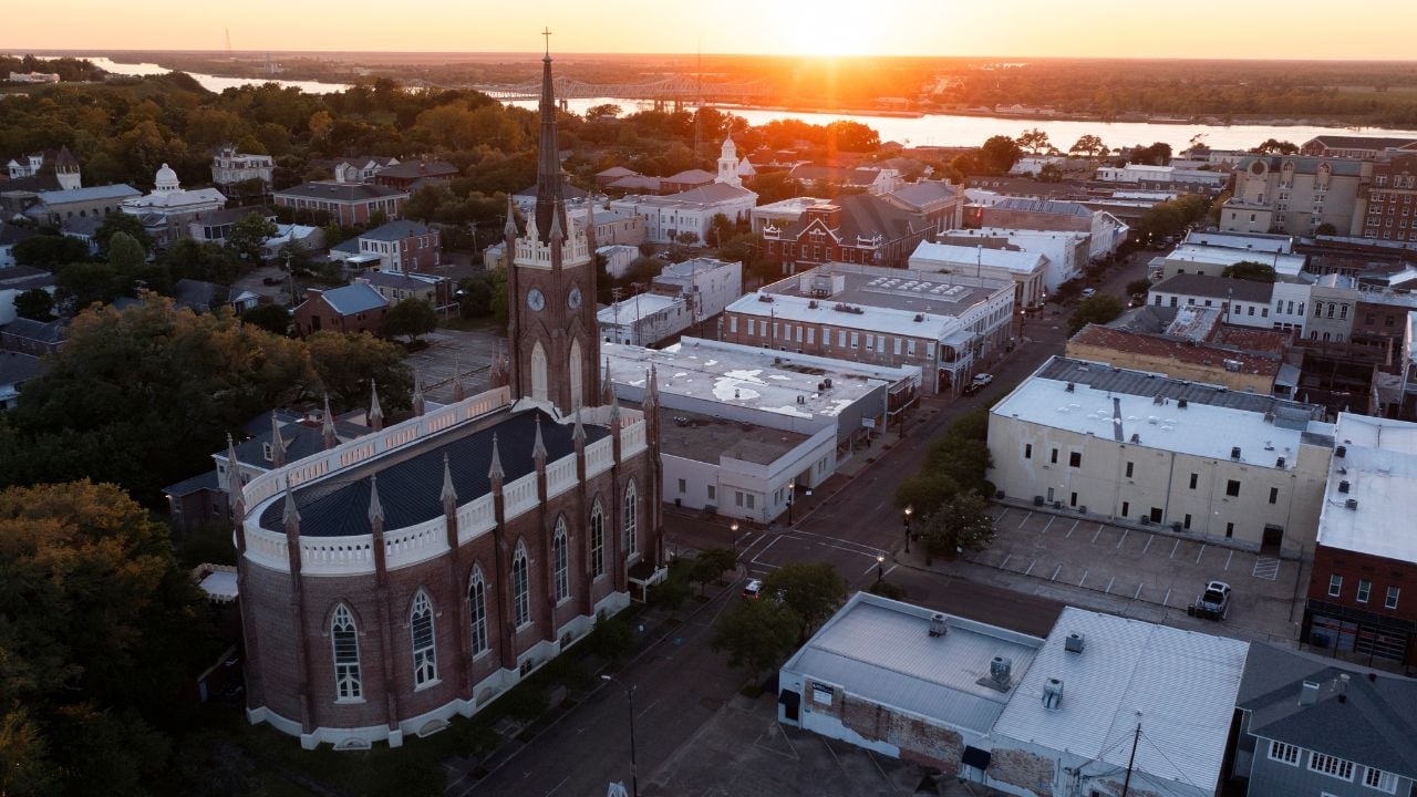 Natchez, Mississippi, USA - April 21, 2024: Sunset light shines on a historic church and landscape of downtown Natchez.
