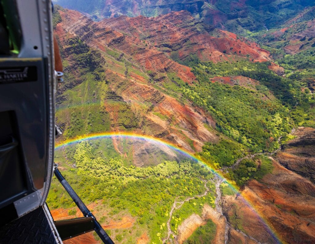 flying over waimea canyn with a double rainbow