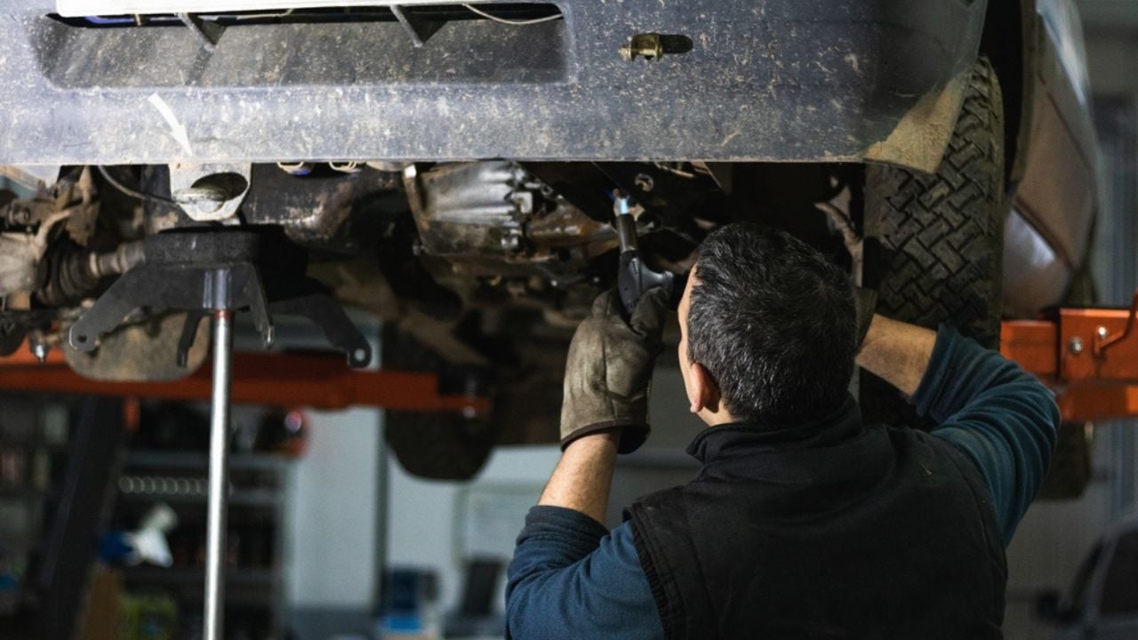 Auto car repair service center. Mechanic examining car suspension