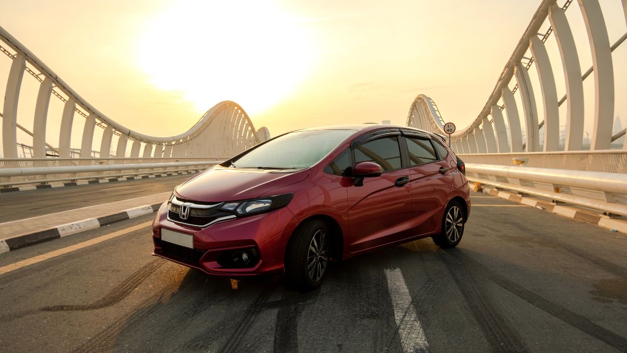 Meydan Bridge, Dubai, UAE - Private car, rouge amethyst 2018 Honda Jazz or Fit GK5 on the bridge during golden hour.
