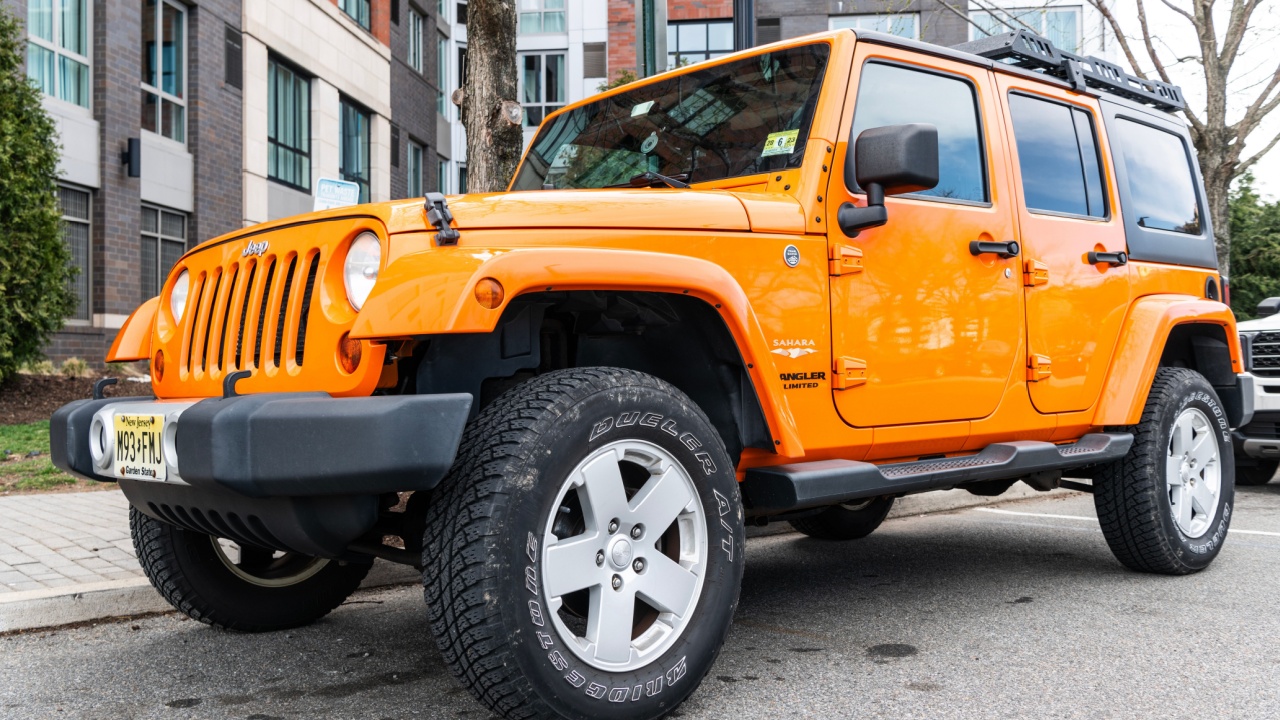 New York City, USA - March 31, 2024: 2012 Jeep Wrangler Unlimited Sahara yellow car parked outdoor, corner view