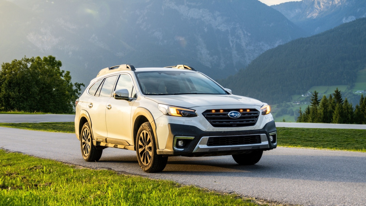 Schladming, Austria - August 25, 2024: White family SUV Subaru Outback in the evening at sunset on the road in the mountains. Off-road car in the Alps in nature between the mountains.