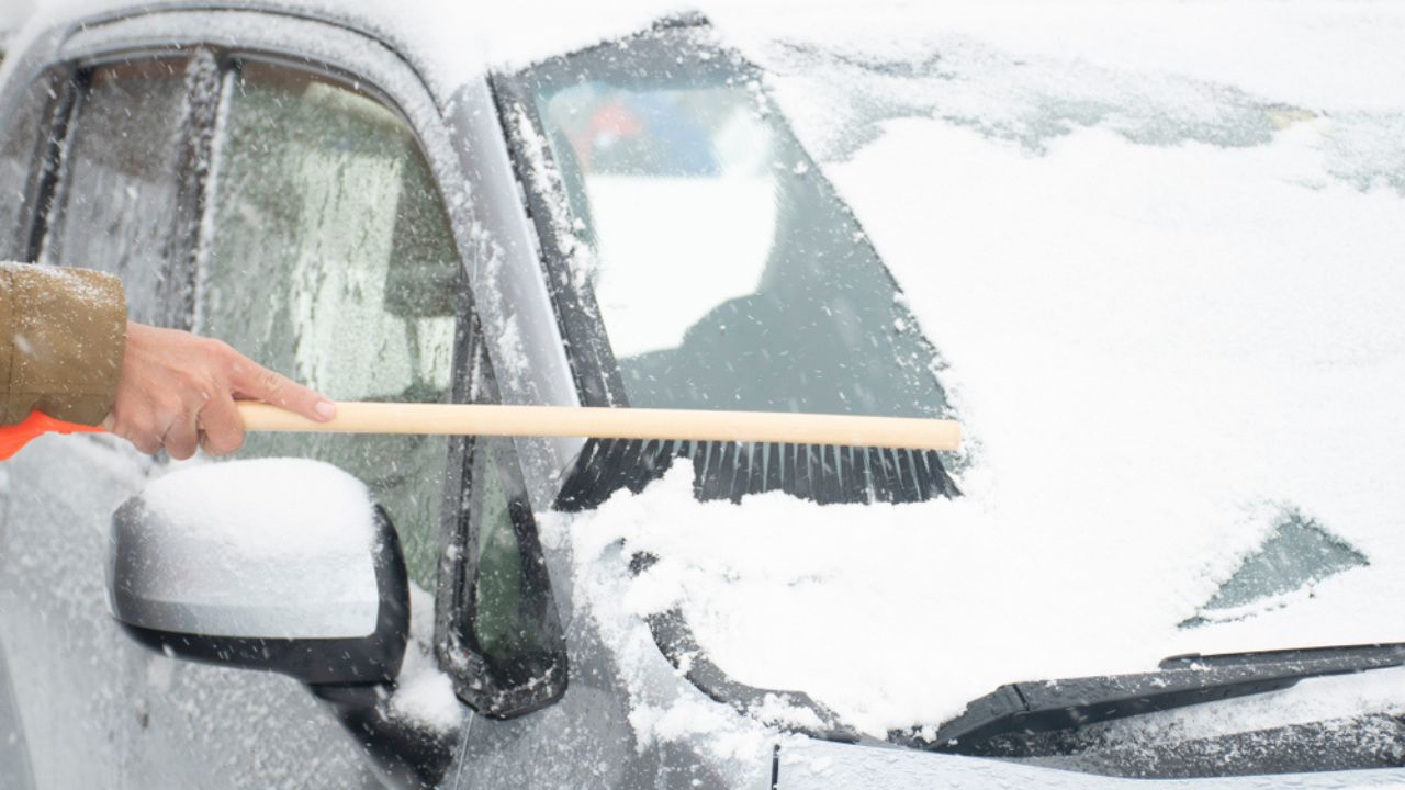 Snow blocked the car's window not good for driving by people is showing how to remove it.