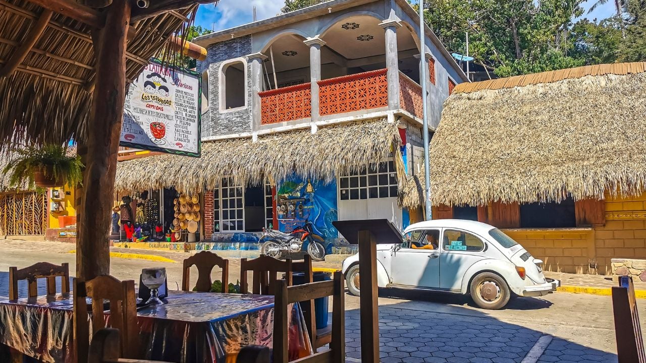 Mazunte Oaxaca Mexico 23. November 2022 Idyllic tourist street with restaurants houses people cars and hotels stores in Mazunte Oaxaca Mexico.