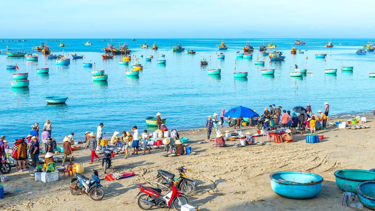 Phan Thiet, Vietnam - February 12th, 2023: Fish market session seas scene people gathered inside basket fish sale, strenuous rowing fishermen brought ashore fishing village in Phan Thiet, Vietnam