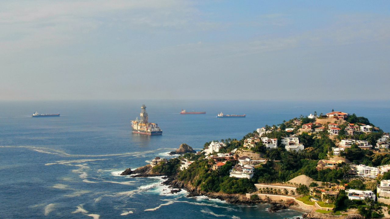 Aerial view of Peninsula de Santiago in city Manzanillo, Mexico. Beautiful bitch and luxury hotels and offshore drilling ship platform and tanker ships at anchor in the bay
