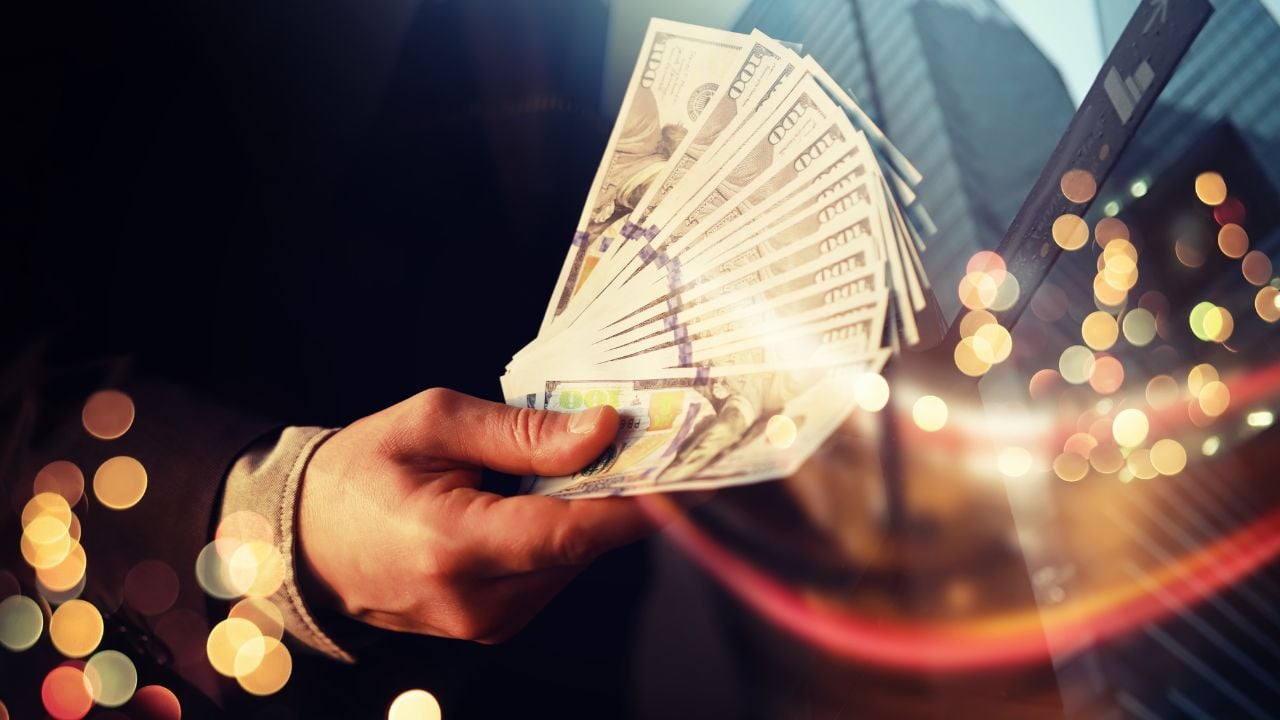 Business Man Displaying a Spread of Cash over a green vintage background