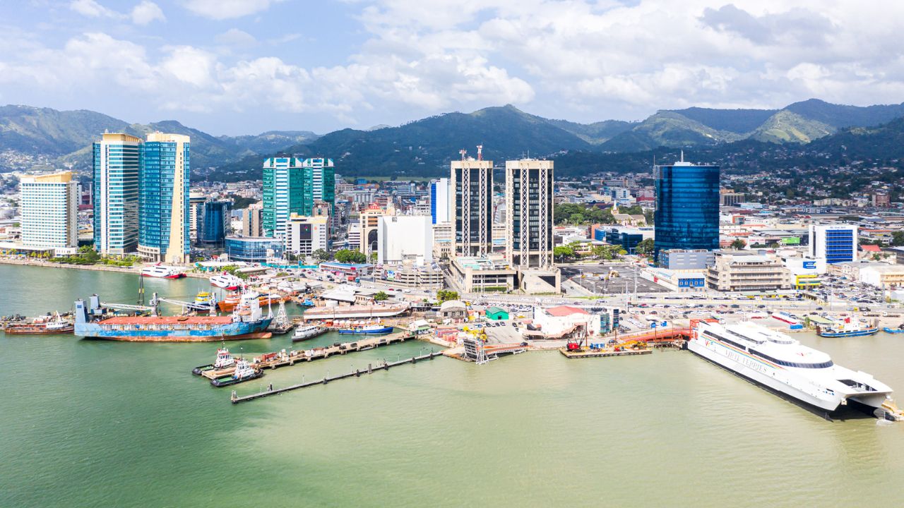 Port of Spain, Trinidad and Tobago - Dec 24 2019: Aerial view of the capital city of a tropical island. Skyscrapers of the downtown and a busy sea port with commercial docks and passenger ships.
