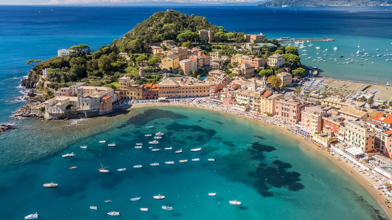 Aerial view of the picturesque resort town of Sestri Levante in Liguria, Italy. Stunning coastal landscape with a moored fishing boats, amazing sandy beach, and elegant historic buildings.
