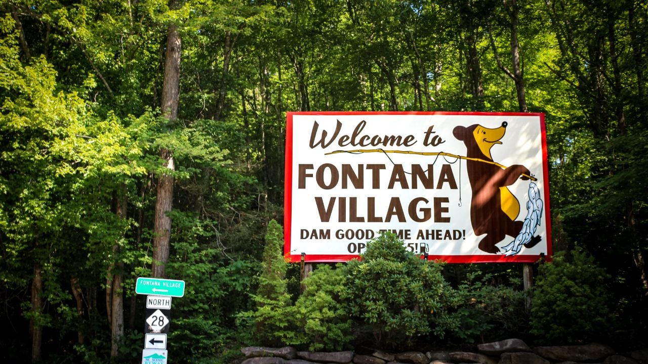 Fontana Dam, NC (USA) - July 5, 2025: A "Welcome to FONTANA VILLAGE" sign, with a bear illustration. It also references the Fontana Dam. For Editorial Use.
