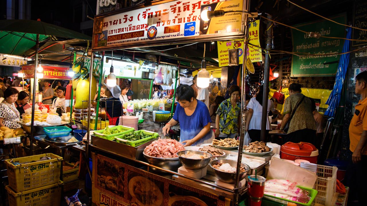 BANGKOK - NOVEMBER 9, 2019 : Tourist buy and eating food at Yaowarat road, main street in Chinatown, The famous night street food in Bangkok on November 9, 2019 at Bangkok, Thailand.