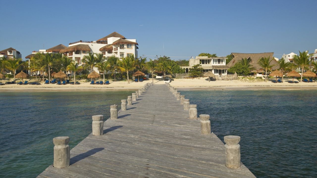 Dock in water looks back at Puerto Morelos, Mexico, South of Cancun in the Yucatan Peninsula, Mexico