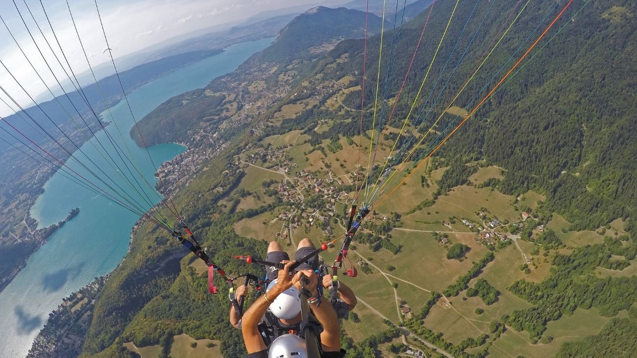 Paraglider tandem flying over blue Lake