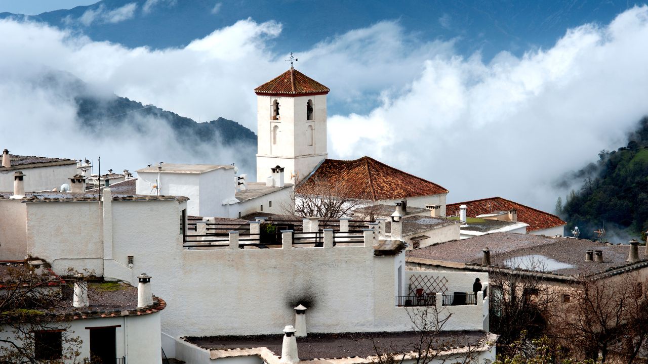 The Alpujarran village and church of Capileira high up in the misty Sierra Nevada mountains in Spain's Andalucia.