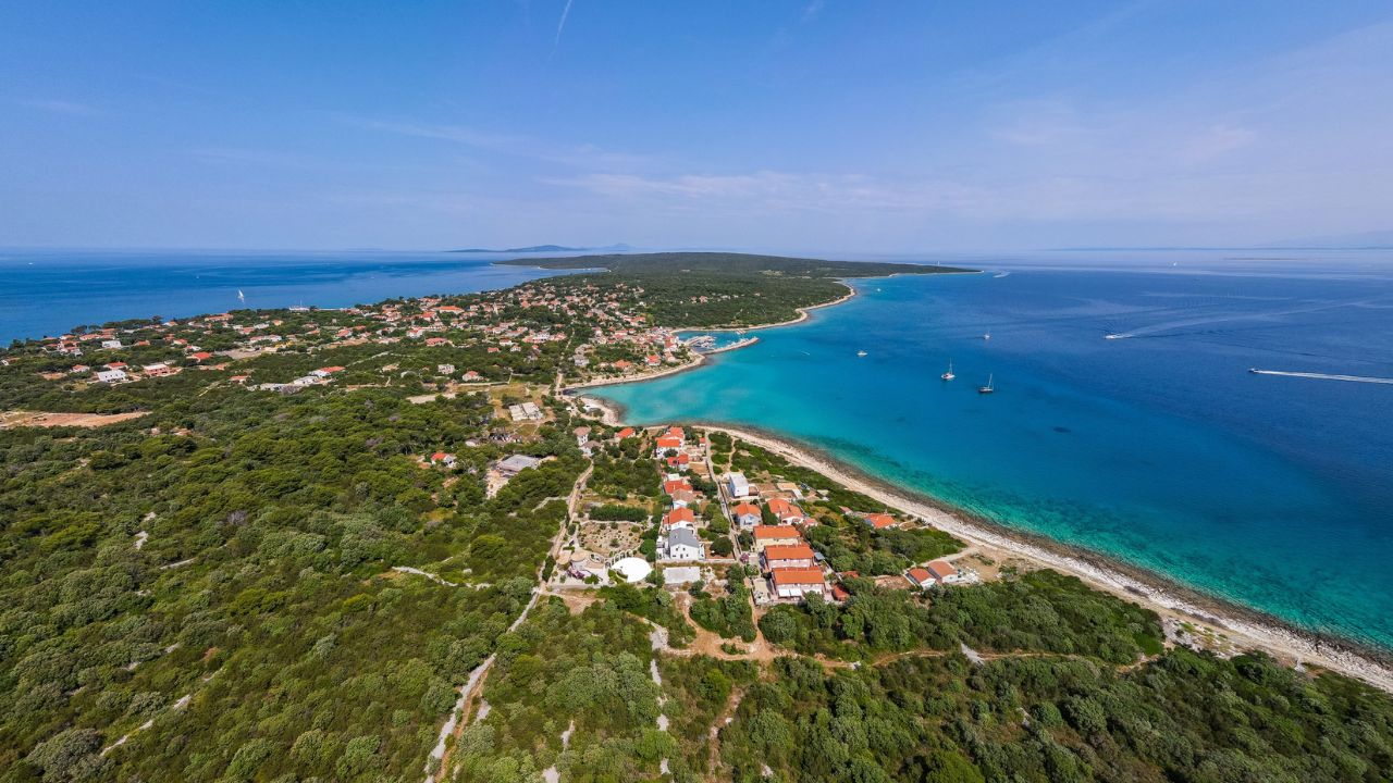 Aerial drone view of Croatian island Silba with beautiful beaches. Amazing Adriatic sea tourist vacation destination in Croatia. Panoramic paradise blue sea, sandy beaches, old houses and boats