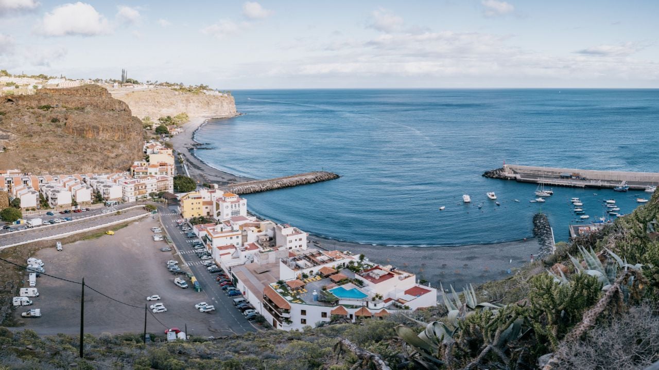 A small village and beach with boats near a mountain by the sea, La Gomera, Canary Islands, Spain