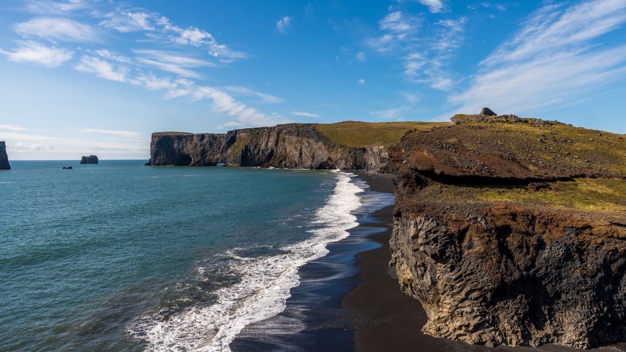 View of the black volcanic sand beach Reynisfjara and the rock formations with sea from Cape Dyrhólaey, Vik, South Iceland