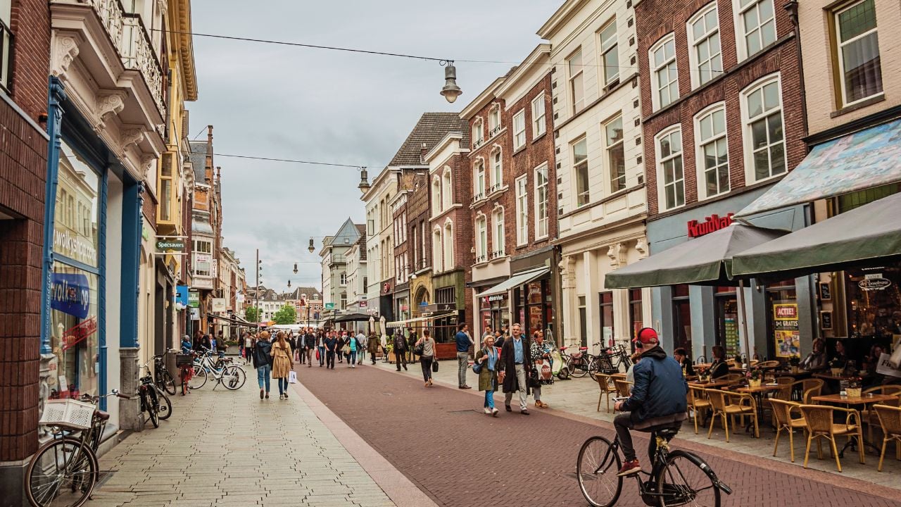 s-Hertogenbosch, southern Netherlands - July 01, 2017. Street with restaurants, shops, cyclist and people strolling in the s-Hertogenbosch downtown. Gracious historical city with vibrant cultural life