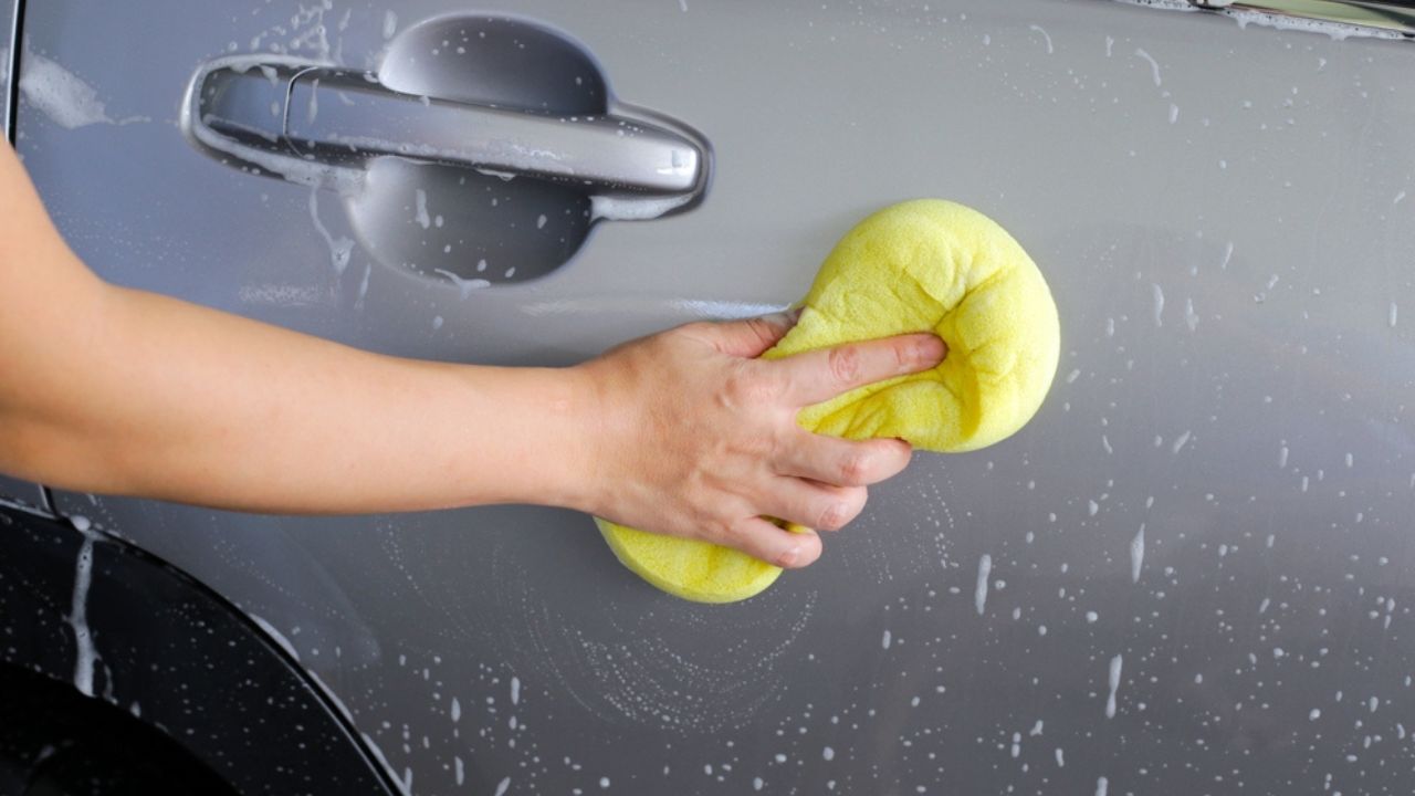 Washing car with yellow sponge