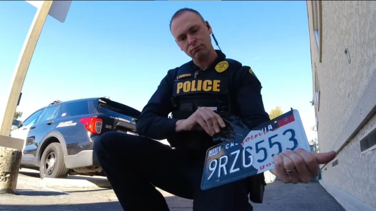 California police holding a modded license plate.
