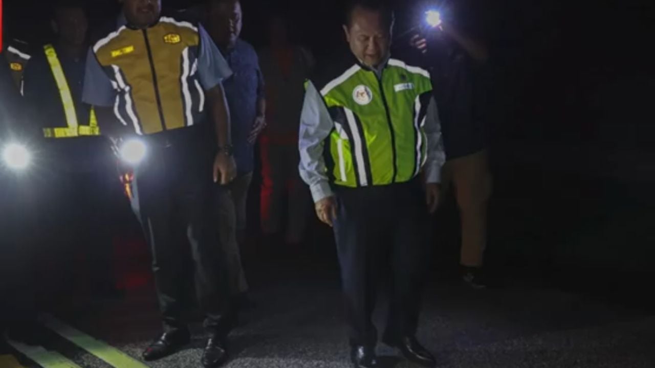 Officials inspecting a road in Malaysia.