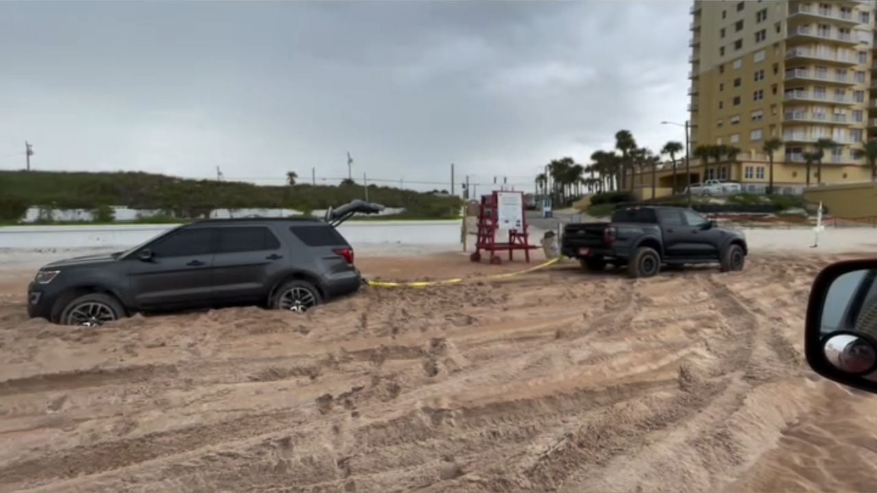Ford Raptor attempts to tow Ford Explorer stuck in beach sand.