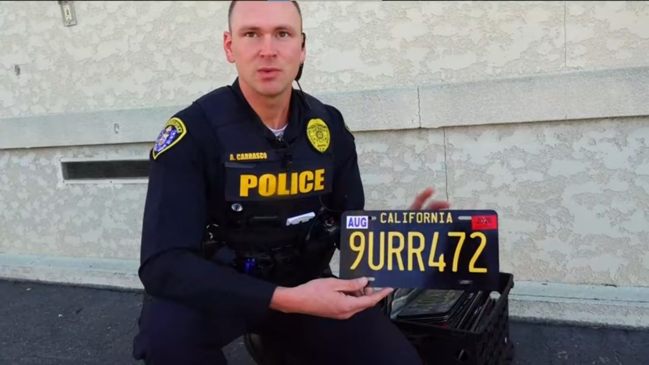California police holding a modded license plate.