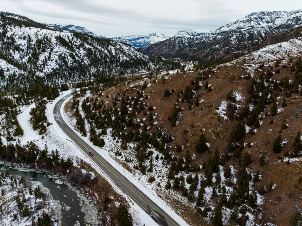 a car driving on the buffalo bill highway near the yellowstone entrance