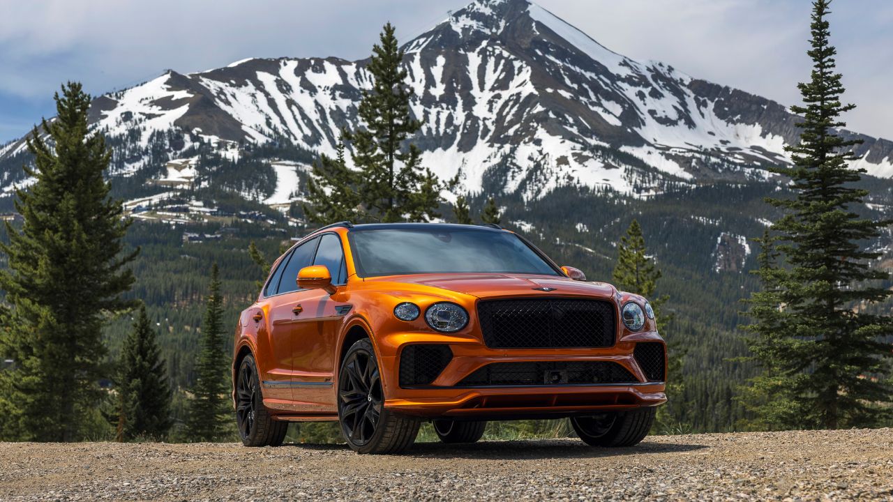 Orange 2026 Bentley Bentayga Speed Front 3/4 view in the mountains
