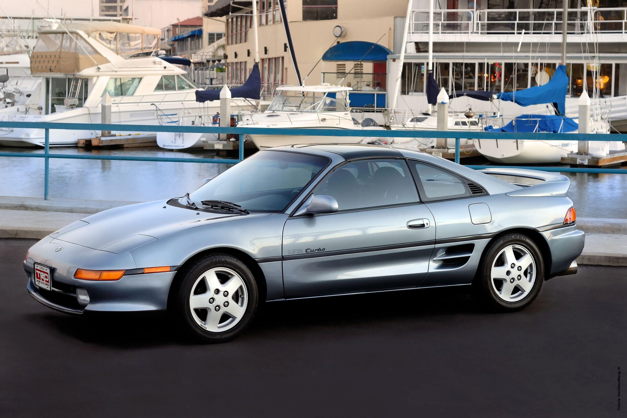 A Toyota MR2 Turbo Posed in Front of a Yacht Harbor